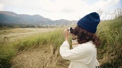 Asian tourist woman taking pictures of the mountainside with her camera at Stock Footage
