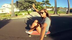 POV happy adventurous girl skateboarding down street at sunset holding selfie camera Stock Footage