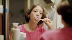 young girl brushing her teeth in front of the mirror Stock Footage