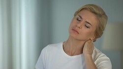 Good-looking blond woman suffering neck pain, sedentary life, health problems Stock Footage
