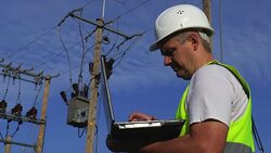 Electrician using portable computer at the high voltage line Stock Footage
