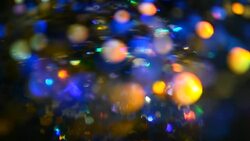 Defocused shimmering multicolored glitter confetti, black background. Party, magic, imagination. Rainbow colors, sparkle circles. Holiday abstract festive texture of shiny blurred bokeh light spots. Stock Footage