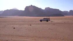 Wadi Rum - a local car crossing fast, in sandstone desert landscape Stock Footage