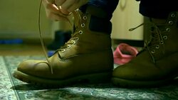 close up person ties warm winter classic shoelaces of boots Stock Footage