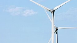 Wind turbines and agricultural fields on a summer day Stock Footage