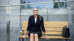 Smiling businesswoman sitting on bench, relaxing after stressful working day Stock Footage