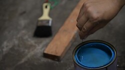 The human hand is stirring color in can Stock Footage