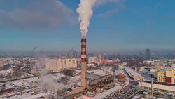Bad ecology. The thermal power plant located in the center of the residential district, throws out smoke from the high pipe, polluting the atmosphere of the city. Aerial drone video with backward camera motion. Stock Footage
