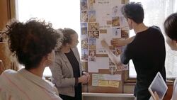 Creative designers reviewing photographs in office meeting Stock Footage