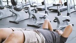 MS overweight Asian man doing sit-ups, side view Stock Footage