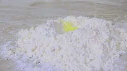 Uncooked egg dropping onto dry ingredients Stock Footage