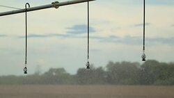 Pivot irrigation system. 120fps slow-motion close-up of pivot sprinkler system irrigating crops. Irrigation pivot system watering agriculture field Stock Footage