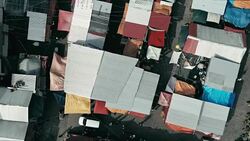 aerial drone footage of the morning city market with colorful tents looking down Stock Footage