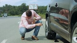 Man lifting car on jack for changing flat tire Stock Footage