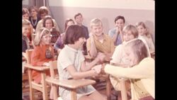 1970s: Girl hands snake to girl sitting behind her Stock Footage