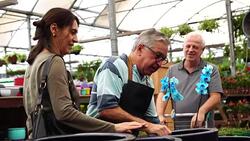 Family shop for plants with Salesman at Flower Market Stock Footage