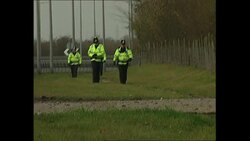 Police officers standing on perimeter of airport News Clip