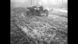 Horse Drawn Cars and Horseless Carriages Drive Across Muddy Track Stock Footage