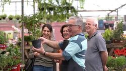 Family shop for plants with Salesman at Flower Market Stock Footage