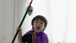 Thai boy with Halloween costume while acting and playing with Halloween skull and spear toy at home-Halloween concept Stock Footage
