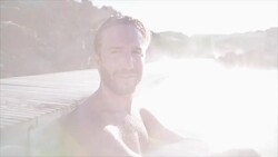 Geothermal spa. Man relaxing in hot spring pool in Iceland. Male enjoying bathing in a blue water lagoon Icelandic tourist attraction Stock Footage