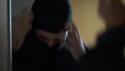 Nervous criminal taking balaclava off and looking into mirror after crime Stock Footage