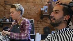 Young hairdressers grooming customers in salon Stock Footage