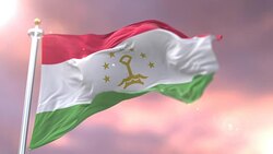 Flag of Tajikistan waving at wind in slow at sunset, loop Stock Footage