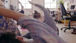 Creative business people practicing yoga in open plan office Stock Footage