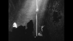 United States, c.1951: A man climbs down a rope into the White Grotto through a hole Stock Footage