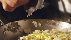 Super slow motion macro of a hand of middle aged chef grating black truffle in pan (close up) Stock Footage