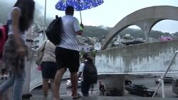 Commuters on rainy day in Rio during spread of Zika virus News Clip