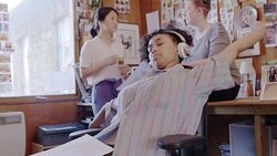 Creative businesswoman reading paperwork and listening to music with headphones in office Stock Footage
