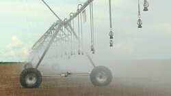 Pivot irrigation system in 4K 60fps. Close-up of pivot sprinkler system irrigating crops. Irrigation pivot system watering agriculture field Stock Footage