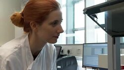 Lab worker looking at robot processing tubes test News Clip