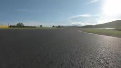POV: Racing behind a red sports car speeding around the circuit on a sunny day. Stock Footage