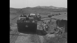 AMTRACs (amphibious tractors) traveling through countryside; prisoners file into them in South Korea during Korean War News Clip