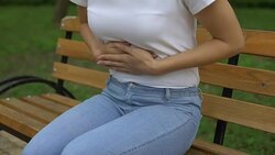 Slim female feeling sharp stomachache, suffering from ulcer in park, health care Stock Footage