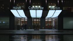 WIDE ANGLE OF HOTEL CONCORDE BERLIN. HOTEL LOBBY VISIBLE IN BG. BELL HOPS WAIT AT REVOLVING FRONT DOORS WITH GUEST'S LUGGAGE. CURBSIDE. LUXURY HOTEL, UPPER CLASS. NX MATCHING HOTEL 3276-018 TO 3276-026, 3276-035, 3276-036. Stock Footage