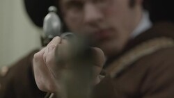 Young man in Revolutionary War uniform aiming barrel Stock Footage