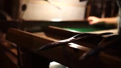 Craftsman working on huge old wooden brocade weaving looms Stock Footage