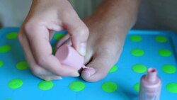 girl paints her nails on her right foot Stock Footage