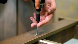 Attach the bracket with a screw using a screwdriver. Close-up. furniture Stock Footage