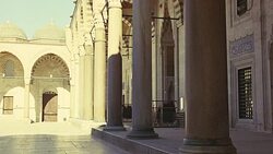 WIDE ANGLE OF INTERIOR STONE COURTYARD. PILLARS OR COLUMNS. STRIPED POINTED ARCHES. ISLAMIC ARCHITECTURE. SULEYMANIYE MOSQUE. DOMES VISIBLE IN BG. Stock Footage
