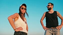 young woman and man enjoying the sunset in front of a blue sky Stock Footage