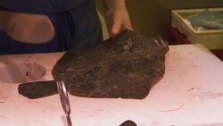 Fish vendor fillets flatfish for sale in seafood market Stock Footage