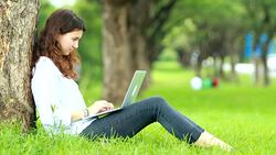 Beautiful woman a smiling with using laptop in the outdoor garden Stock Footage