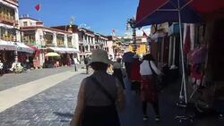 Pilgrims holding prayer wheel walking on Barkhor Street. Stock Footage