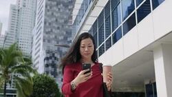 Chinese Woman With Mobile Phone Walking And Drinking Coffee Stock Footage