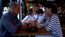 Woman listening to male date looking very interested and happy while both are enjoying drinks and sweet pastry Stock Footage